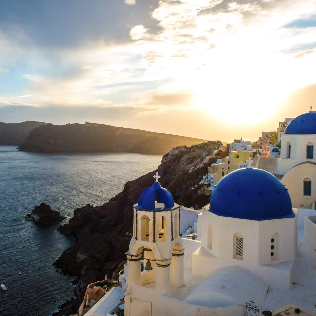 Watching the sunset over Santorini’s blue domes.